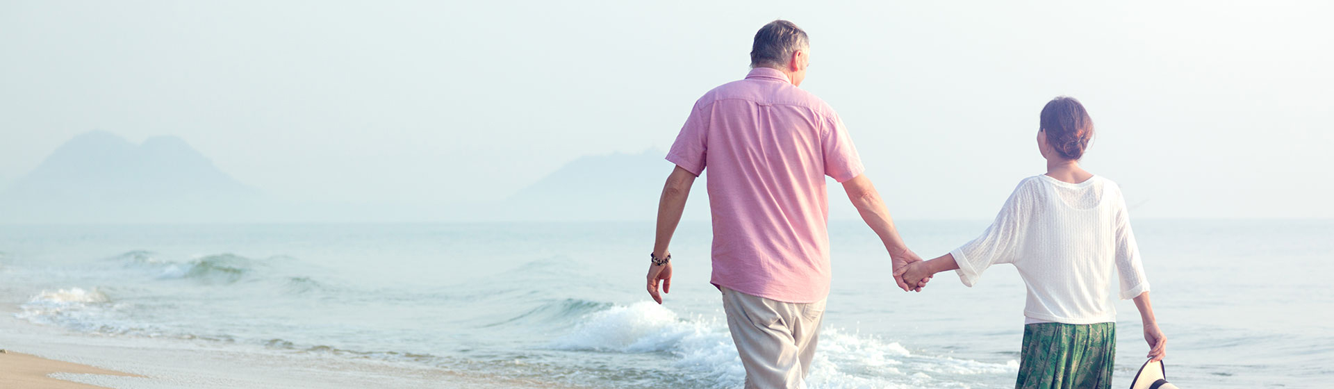Couple walking on the beach holding hands