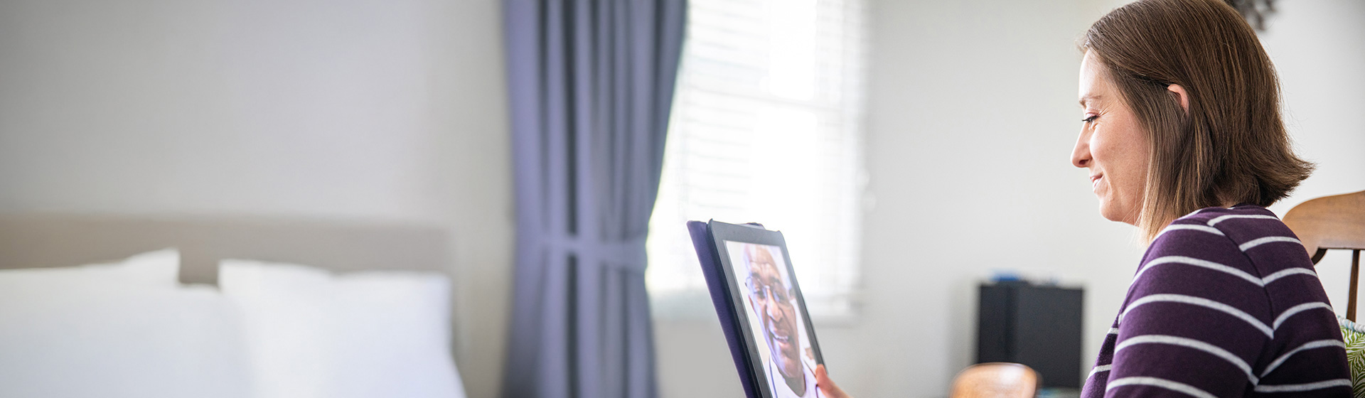 Adult woman connecting with a virtual provider on her laptop during a virtual primary care appointment