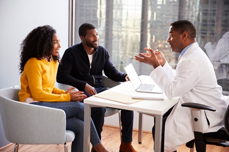 A man and woman converse with a physician.