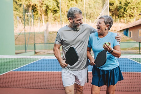 An older couple playing a sport together.